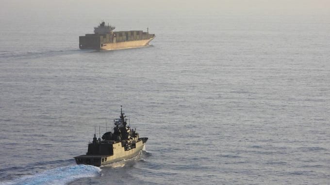 warship escorting containership in the Red Sea