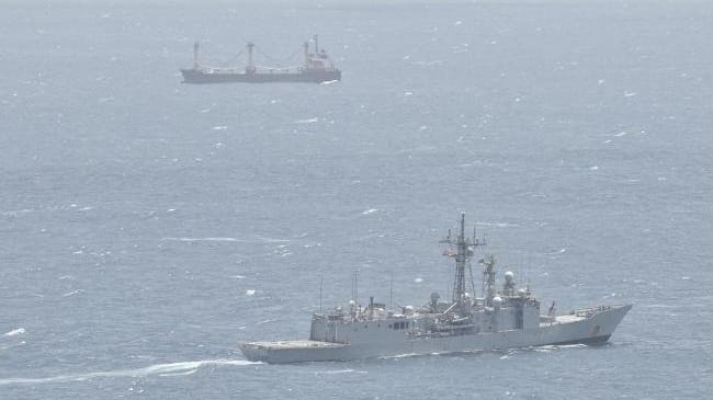 warship monitoring hijacked merchant ship