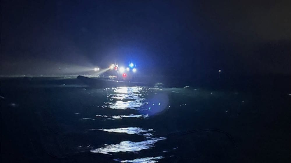 search for missing woman and child after boat was run over by cargo ship