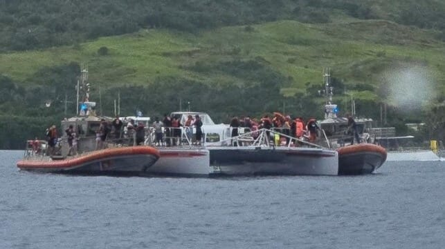 USCG boat crews evacuate a catamaran