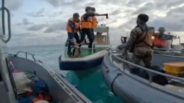 China Coast Guard servicemember threatens a Philippine soldier with an axe, June 17 (AFP)