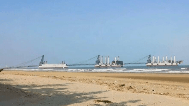Haze-gray jackup barges in a beach logistics exercise at Zhejiang, China, 2025 (Chinese social media)