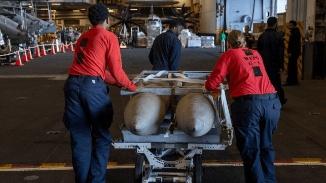 Sailors aboard USS Harry S. Truman move a pair of bombs to the flight deck (USN)
