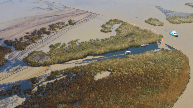 A containment boom (upper center) has been deployed to keep the spill from spreading (USCG)
