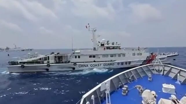 A China Coast Guard vessel cuts across the bow of a Philippine Coast Guard cutter, risking collision, while a second CCG cutter waits in the background (center left) (PCG / Sen. Migz Zubiri)