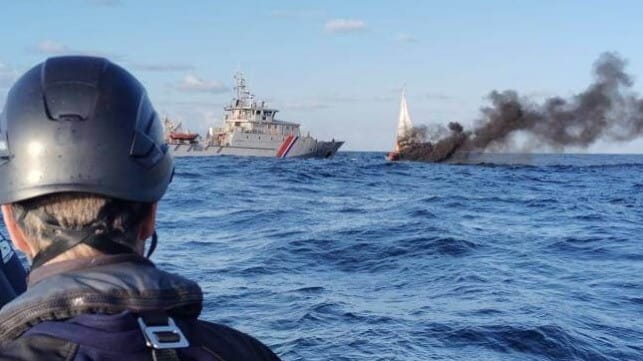 Burning sailboat with French customs vessel