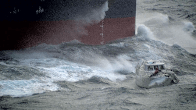 The merchant ship Green Azure approaches the yacht to attempt a rescue (Courtesy RAF)