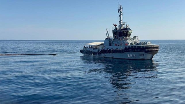 tug spraying dispersant and towing oil boom