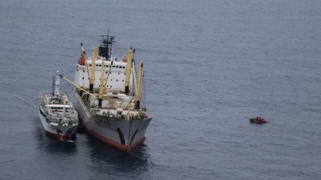 A fishing vessel transfers cargo to a reefer ship on the high seas (USCG file image)