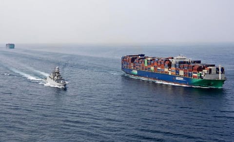 warship escorting containership in the Red Sea
