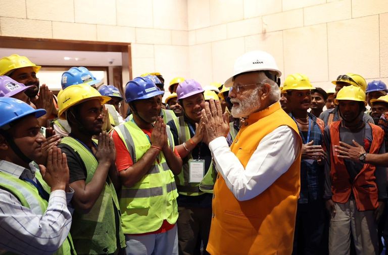Prime Minister Modi in a hard hat mixes in amongst Indian construction workers (KARAM)