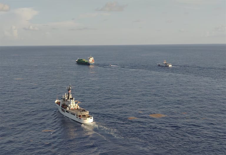 USCG cutters escorting containership