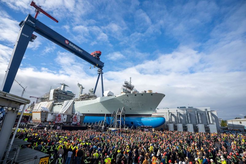 Hundreds of shipyard workers gather for the keel-laying for the future CCGS Imnaryuaq, with a nearly-completed naval auxiliary in the background (CCG)