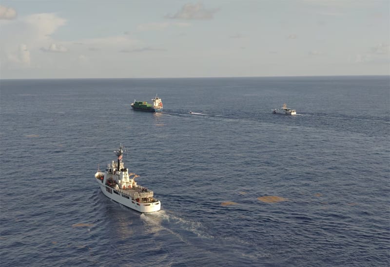USCG cutters escorting containership
