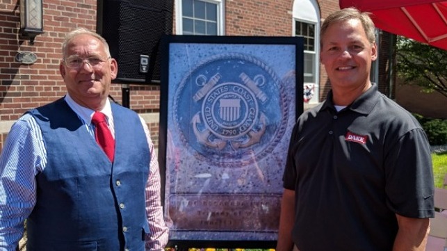 Mitch Mittlestadt and Mike Smith, USCG (retired) in front of the photo of the plaque at the unveiling ceremony