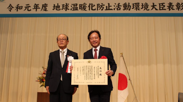 Parliamentary Vice-Minister of the Environment Tetsuya Yagi (Left) presents the Japanese Government Award for Global Warming Prevention Activity Award to NPMC President Seiichiro Shirahata 