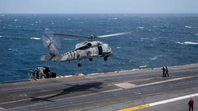 Helicopter leaving flight deck of USS Nimitz