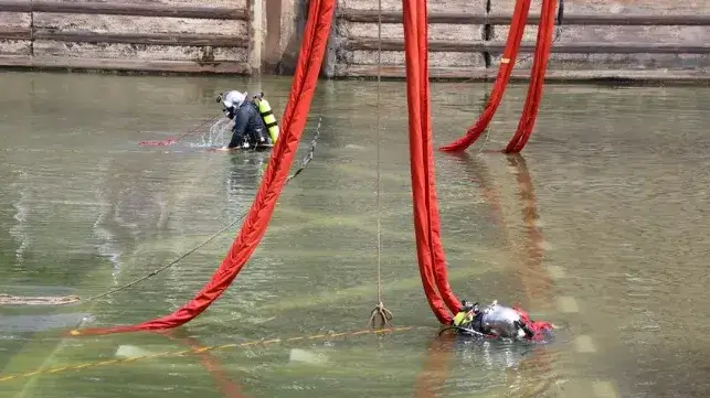 Two commercial divers place rigging during an Army Corps of Engineers construction project (USACE file image)