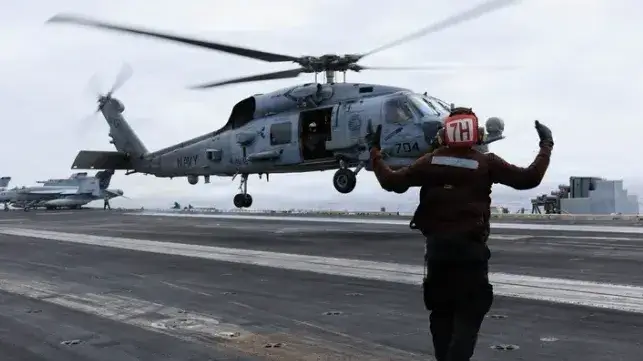 A helicopter takes off from the deck of USS George H.W. Bush, June 2026 (USN)