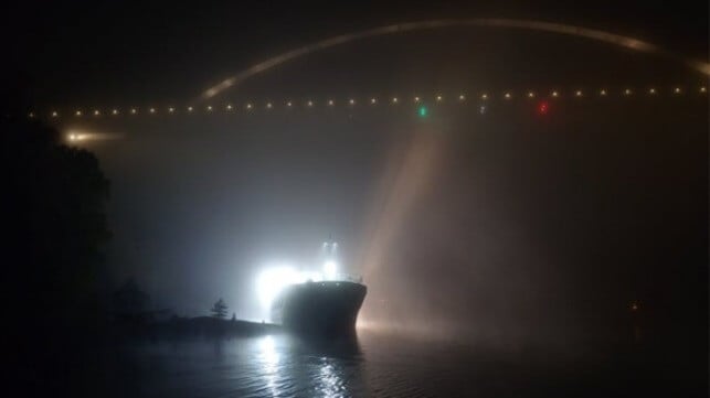 cargo ship aground under roadway bridge