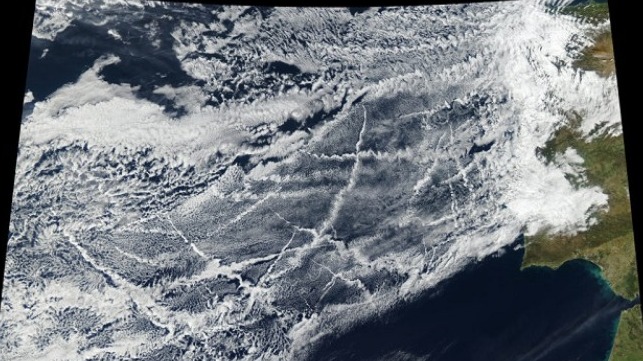 Pollution from ships creates lines of clouds that can stretch hundreds of miles in this satellite image taken 16 January 2018, off the coast of Europe. The narrower ends of the clouds are youngest, while the broader, wavier ends are older. Credit: NASA Earth Observatory