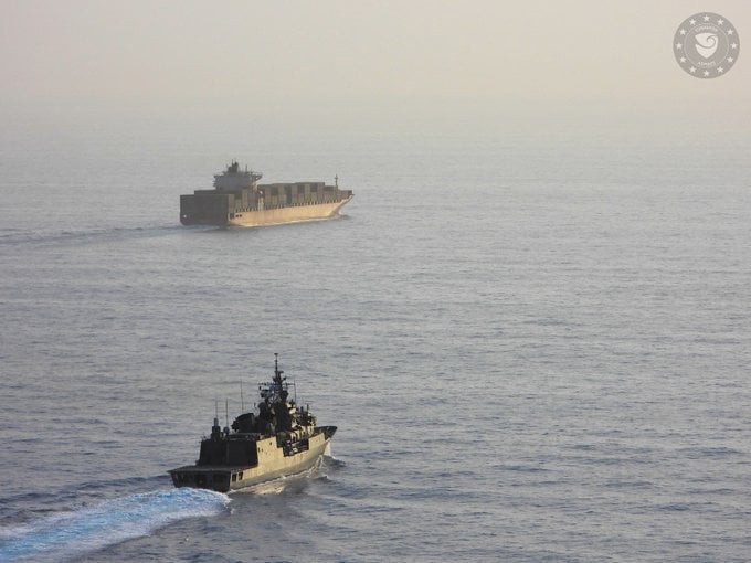 warship escorting containership in the Red Sea
