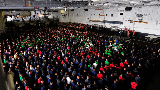 Navy sailors listen to a speech aboard USS Carl Vinson