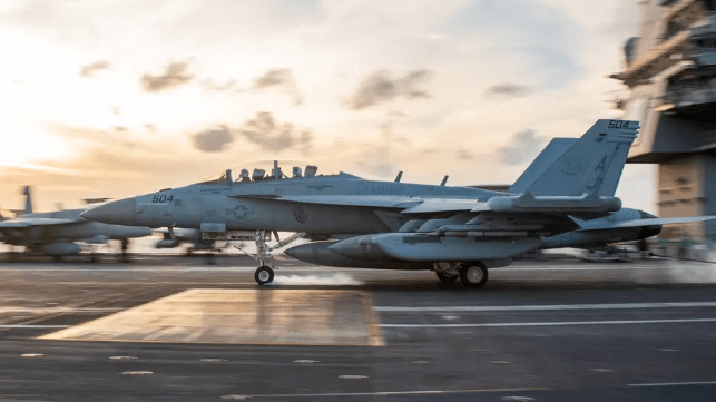 USS Ford's flight deck and a landing E/A-18 Growler