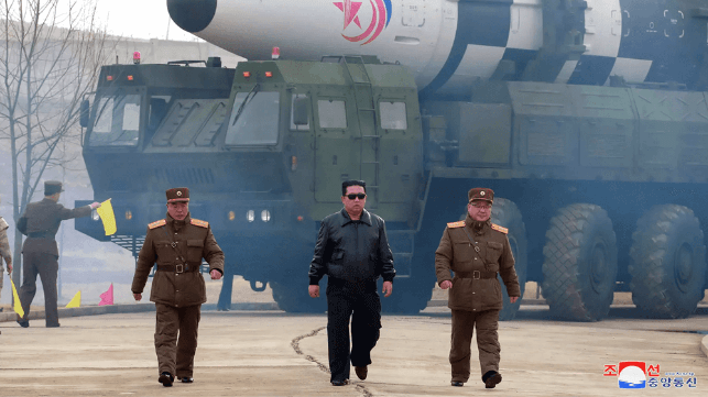 North Korean dictator Kim Jong Un marches along with an ICBM launcher, 2022 (KCNA)