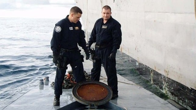 Members of LEDET 404 examine a semi-submersible drug-running craft they seized in 2008. U.S. Coast Guard photo.
