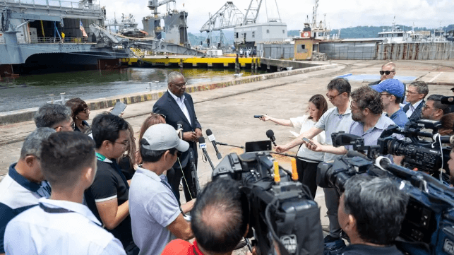 U.S. Defense Secretary Lloyd Austin meets with reporters at Subic Bay, with a U.S. Navy transport in the background, July 2024 (Pentagon)