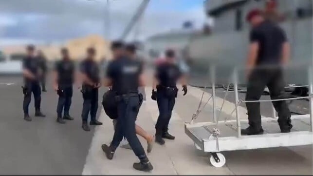 Spanish police transfer a suspect from the fishing vessel into custody onshore (Policia Nacional)