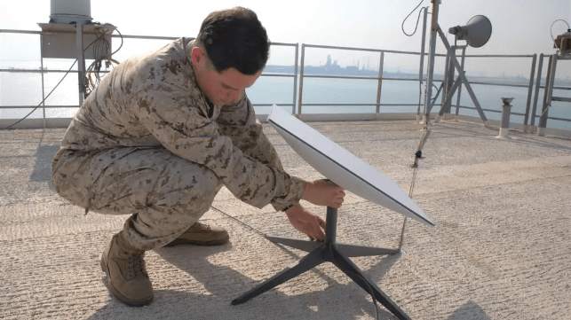 U.S. Marine Sgt. Steven Ramos sets up a Starlink terminal aboard USS Lewis B. Puller, 2023 (USN)