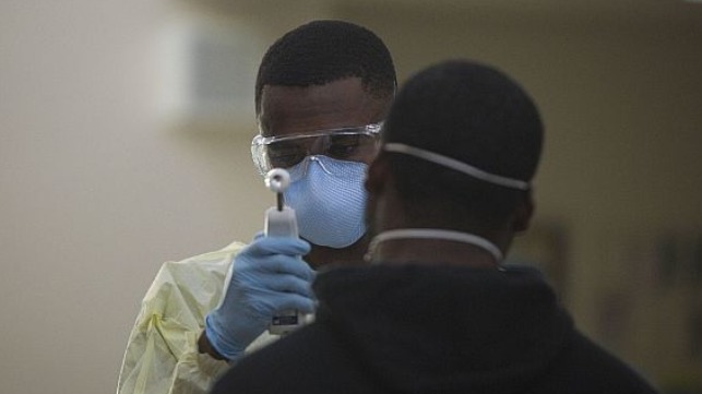 Hospital Corpsman 3rd Class Tavish Davis with 3rd Medical Battalion, 3rd Marine Logistics Group, tests a Sailor assigned to the aircraft carrier USS Theodore Roosevelt (CVN 71) for symptoms of COVID-19, on Naval Base Guam.