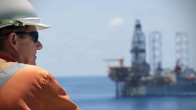 Man looking at oil rig