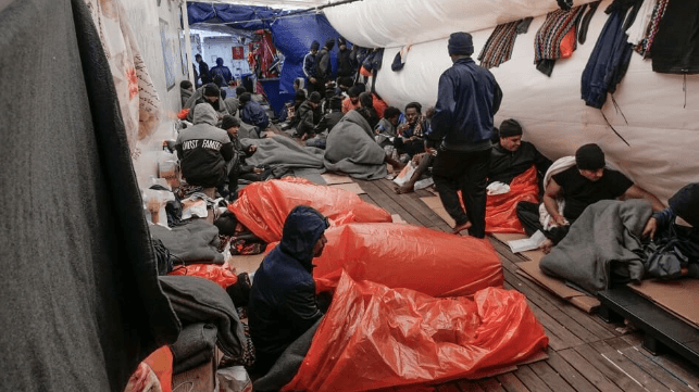 SOS Mediterranee photo of migrants housed in a tent on the back deck of the anchor handler Ocean Viking