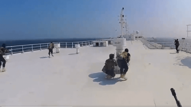 Houthi fighters advance along the top deck of the Galaxy Leader (Houthi Military Media)