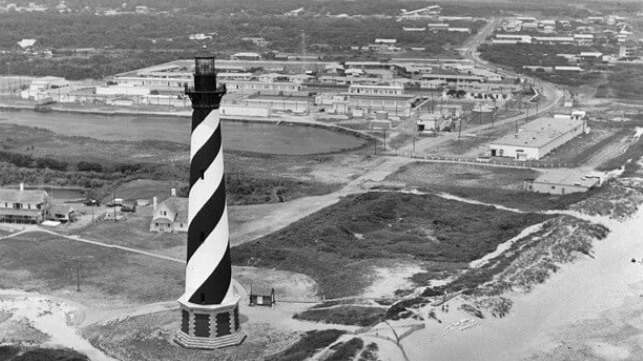Naval Facility Cape Hatteras, a secret SOSUS hydroacoustic listening station, is seen in the background behind the Cape Hatteras Light (USN file iamge)