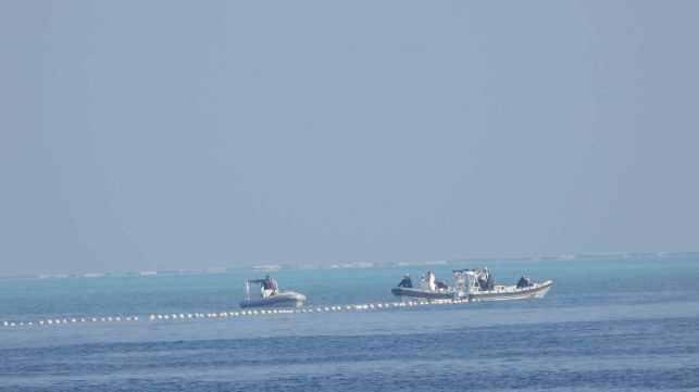 In this 2023 file image, Chinese forces at Scarborough Shoal deploy a barrier (PCG)