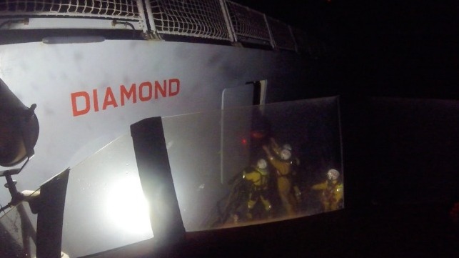 HMS diamond at night helping rescue four yacht passengers