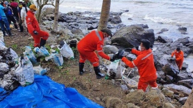 Philippine Coast Guard personnel and cadets from the Philippines' Norwegian Training Center clean oil off the rocks at the town of Pola (PCG)
