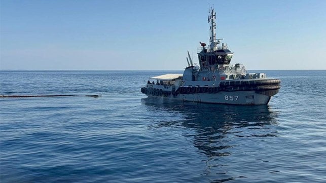 tug spraying dispersant and towing oil boom