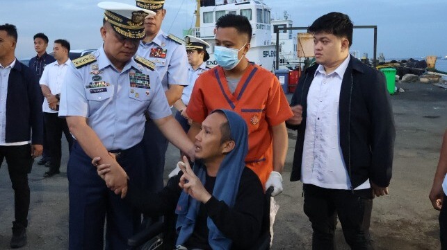 A survivor from Devon Bay speaks with PCG Commandant Adm. Ronnie Gil Gavan, left (PCG)