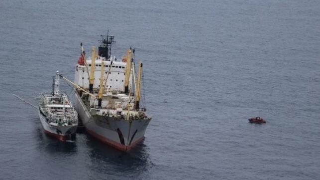 A fishing vessel transfers cargo to a reefer ship on the high seas (USCG file image)